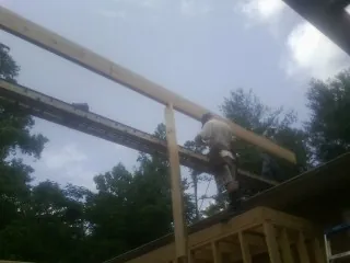 Carpenter setting a ridge beam over a new addition frame — Ice Dam Removal by Roofing Brothers in Staten Island