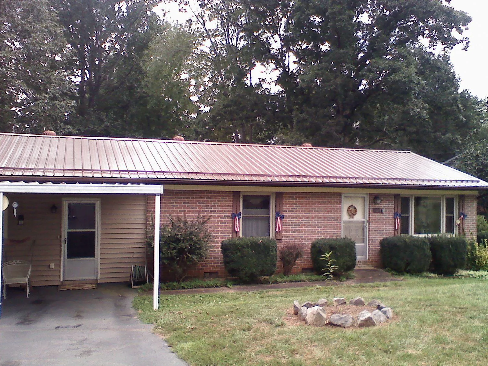 Bronze metal roof and carport on a brick ranch home — Roof Repair work by our crew in Staten Island